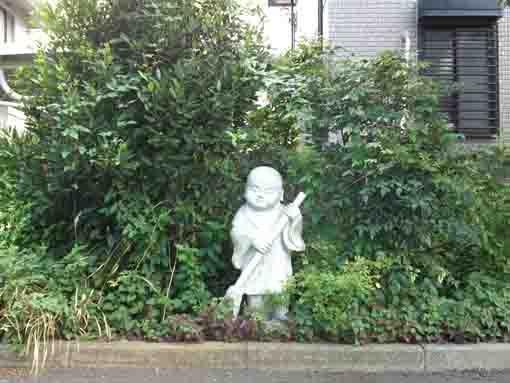 the stone statue of a young priest